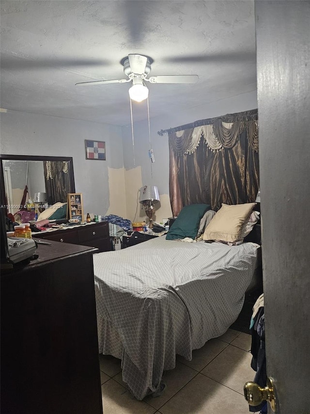 tiled bedroom with a textured ceiling and a ceiling fan