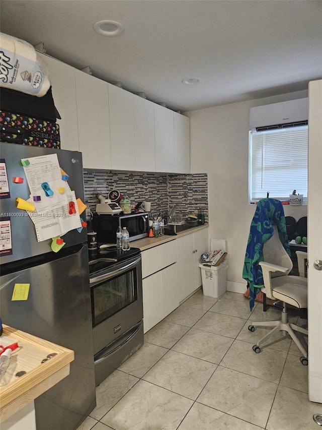 kitchen featuring decorative backsplash, light tile patterned flooring, white cabinets, stainless steel appliances, and a wall mounted AC