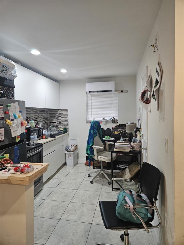 kitchen with a wall mounted air conditioner, stainless steel microwave, white cabinets, butcher block counters, and decorative backsplash