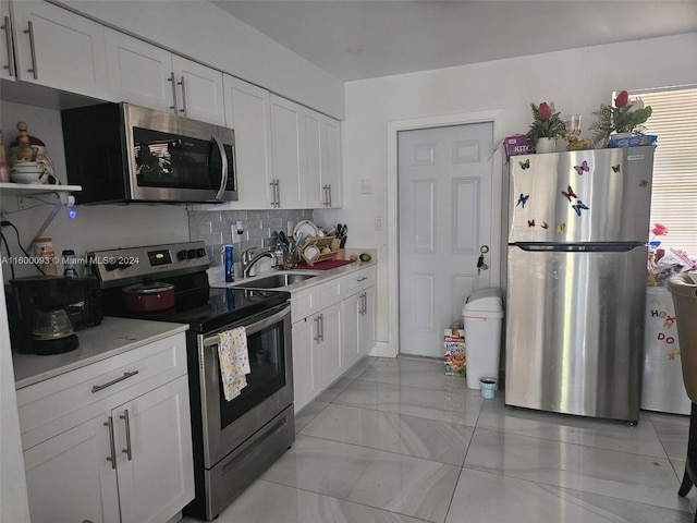 kitchen featuring a sink, light countertops, backsplash, and stainless steel appliances