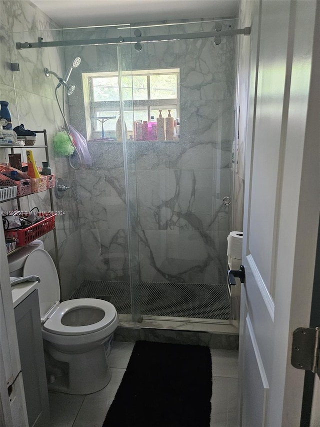 bathroom featuring a marble finish shower, toilet, vanity, and tile patterned flooring