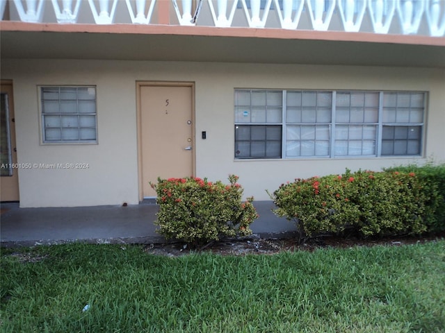 entrance to property with a lawn