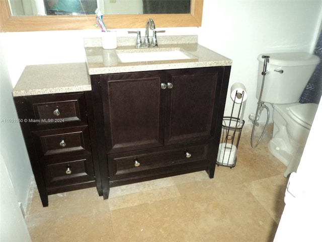 bathroom with tile flooring, toilet, and vanity