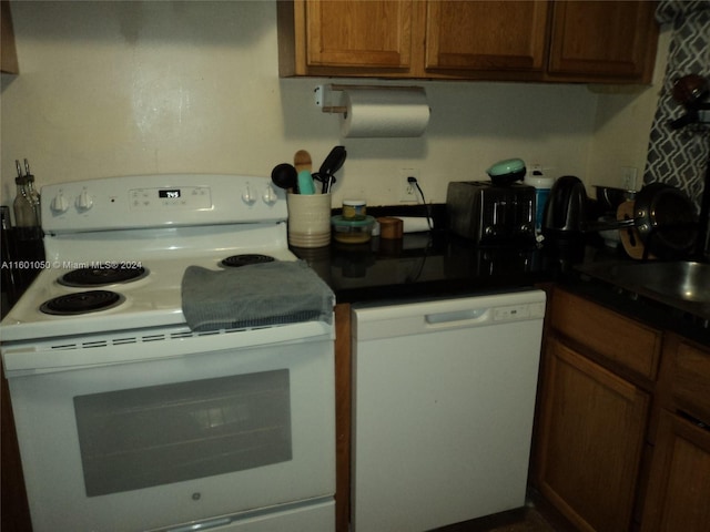 11855 NE 19th Dr Unit 5, North Miami, FL 33181 - kitchen featuring white appliances, brown cabinetry, dark countertops, and a sink