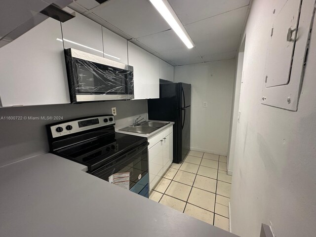 kitchen featuring sink, white cabinetry, light tile patterned floors, and stainless steel appliances