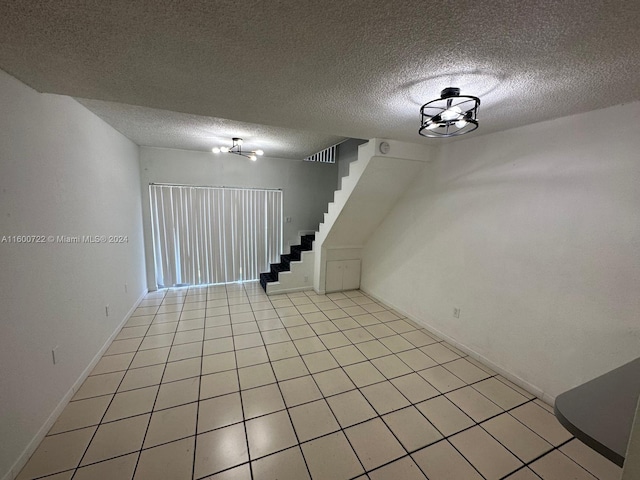 basement featuring a textured ceiling and light tile patterned floors