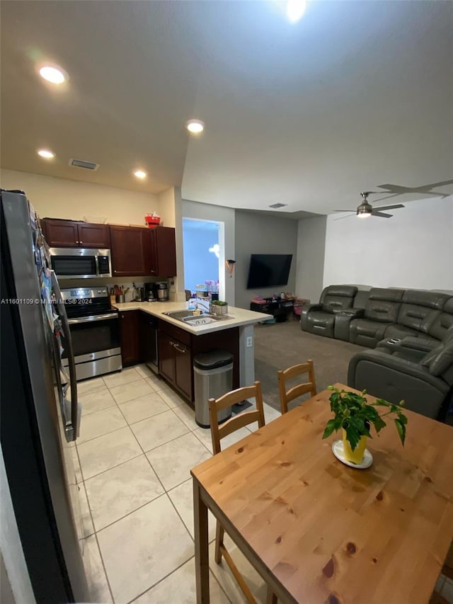 kitchen featuring light tile patterned floors, black appliances, ceiling fan, sink, and kitchen peninsula