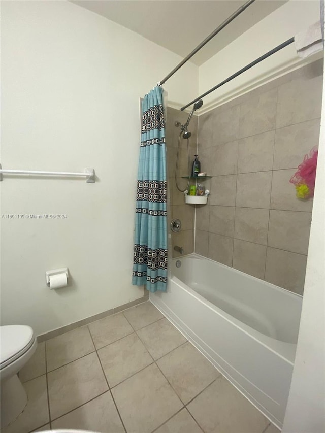 bathroom featuring shower / bath combo with shower curtain, tile patterned flooring, and toilet