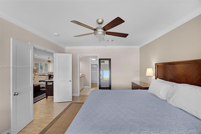 bedroom featuring ceiling fan, light wood-type flooring, ornamental molding, and ensuite bath