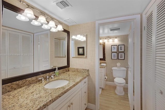 bathroom featuring hardwood / wood-style flooring, vanity, and toilet