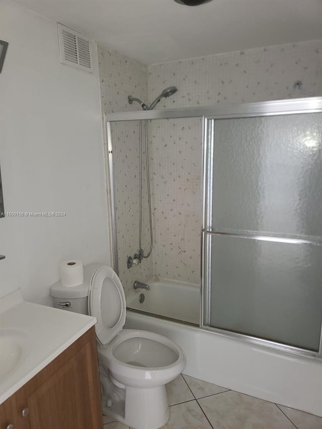 full bathroom with tile patterned floors, vanity, toilet, and enclosed tub / shower combo