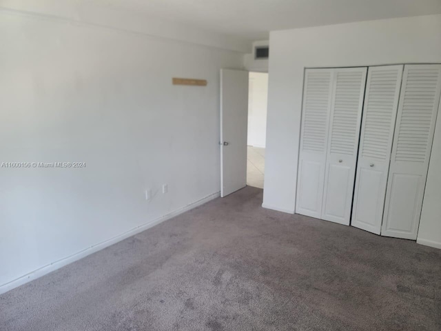 unfurnished bedroom featuring carpet floors and a closet