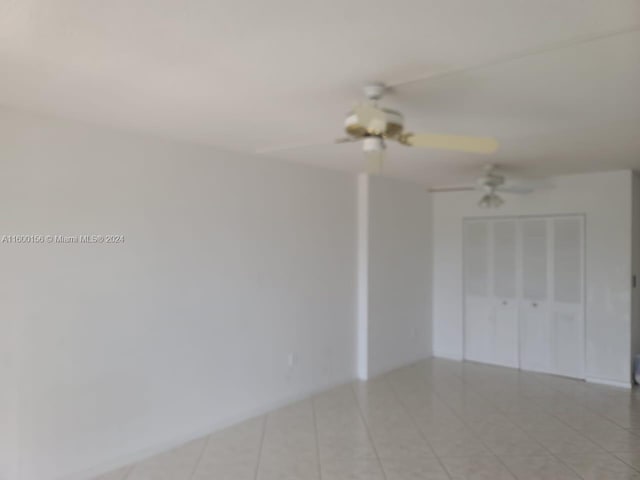 spare room featuring ceiling fan and light tile patterned floors