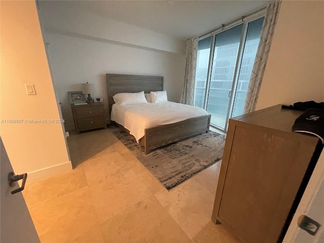 tiled bedroom featuring a wall of windows and access to exterior