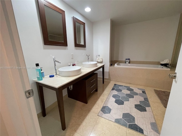 bathroom featuring tile patterned floors, a bathing tub, and double vanity