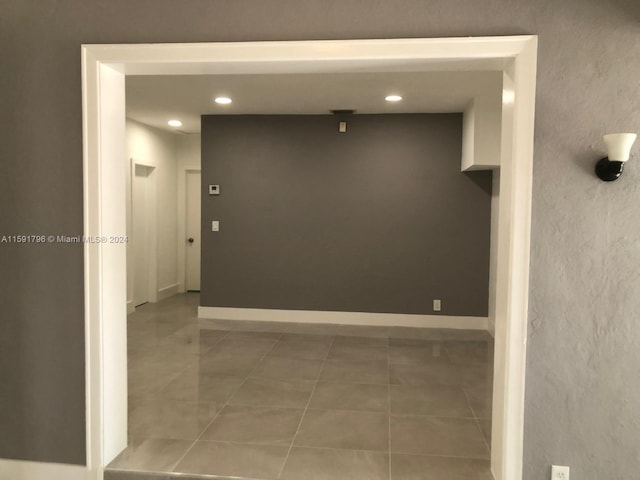 hall with tile patterned floors