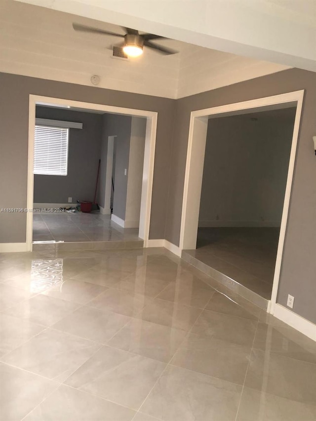 empty room with tile patterned flooring and ceiling fan