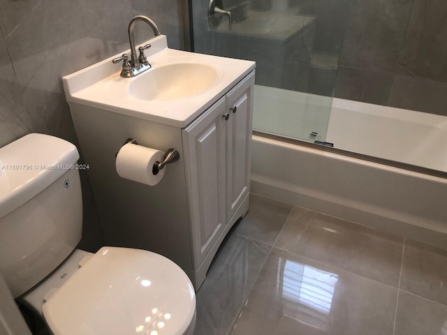 full bathroom featuring tile patterned floors, vanity, enclosed tub / shower combo, and tile walls