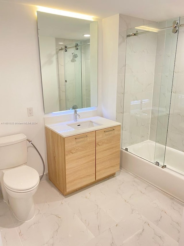 full bathroom featuring vanity, toilet, and bath / shower combo with glass door