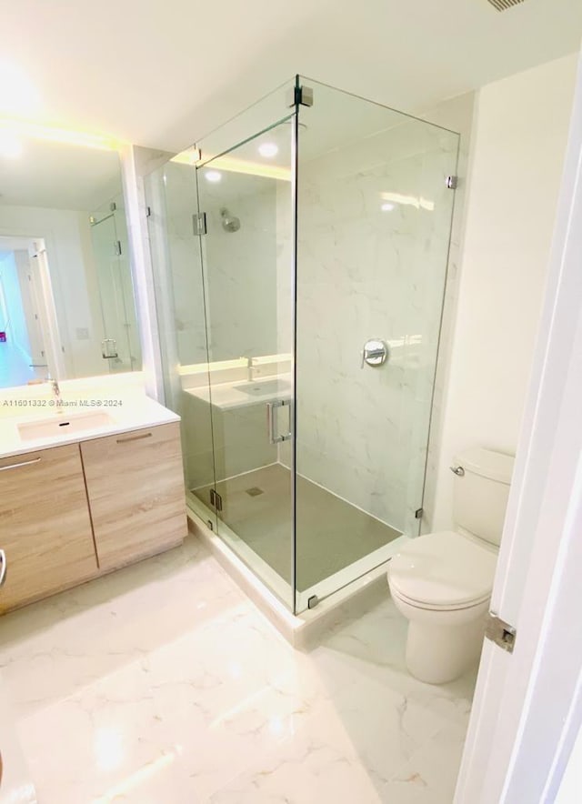 bathroom featuring an enclosed shower, vanity, and toilet