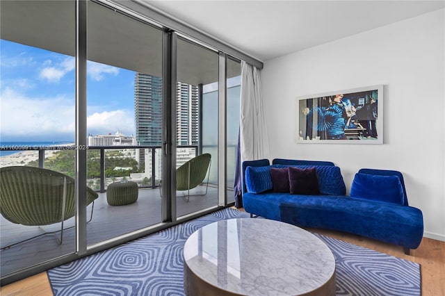 living room featuring expansive windows, hardwood / wood-style flooring, and a water view