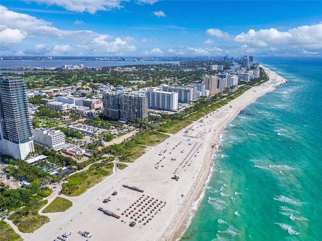 birds eye view of property featuring a beach view and a water view