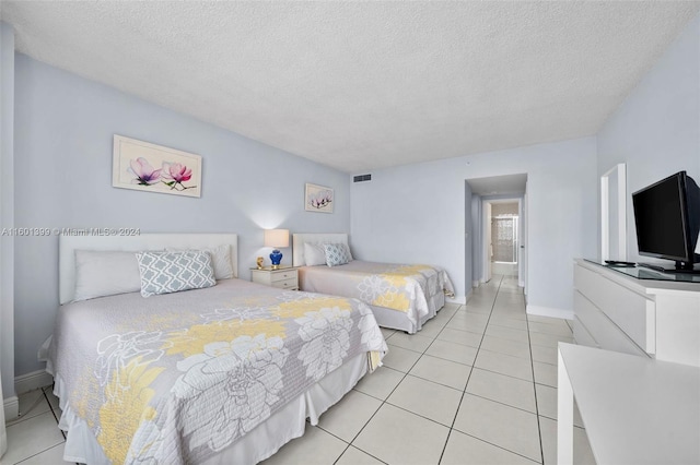 tiled bedroom featuring a textured ceiling