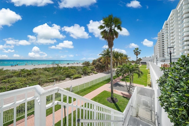 view of water feature with fence private yard and a view of the beach