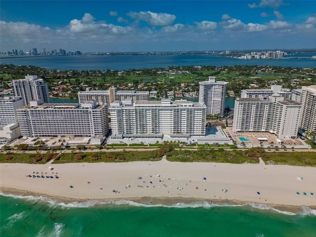 aerial view with a beach view, a water view, and a view of city