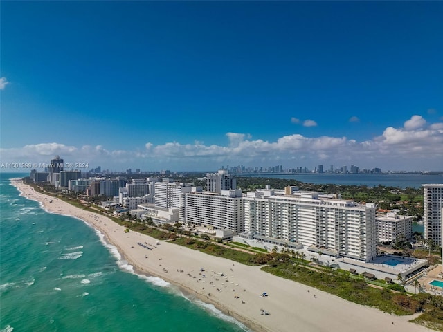 drone / aerial view featuring a view of city, a water view, and a view of the beach
