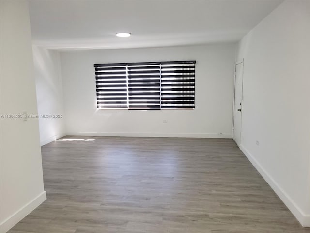 unfurnished room with hardwood / wood-style flooring