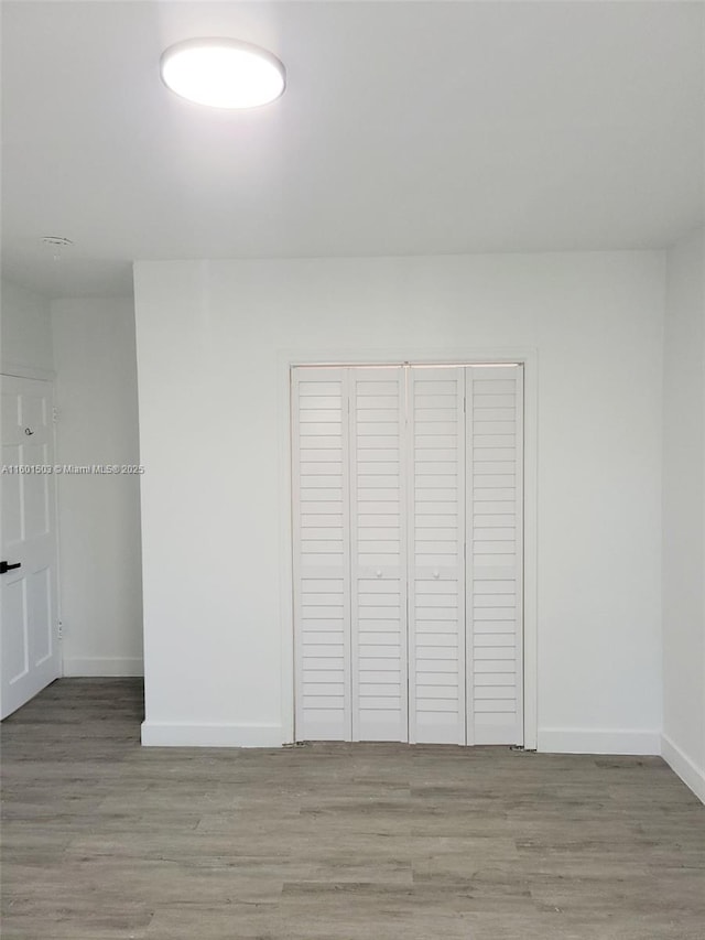 unfurnished bedroom with a closet and hardwood / wood-style flooring