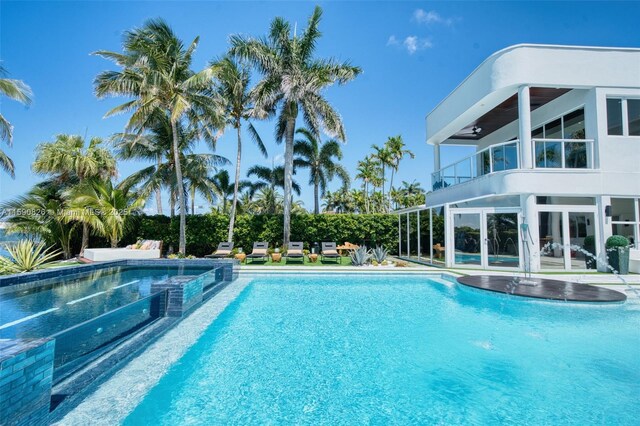 view of swimming pool with an in ground hot tub, a yard, and a water view