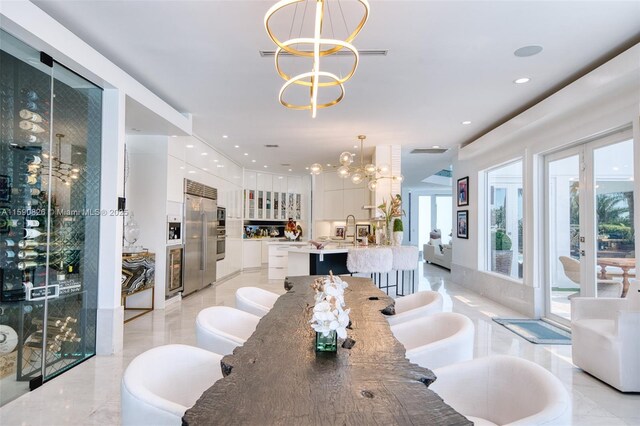 dining room featuring sink, french doors, and a notable chandelier