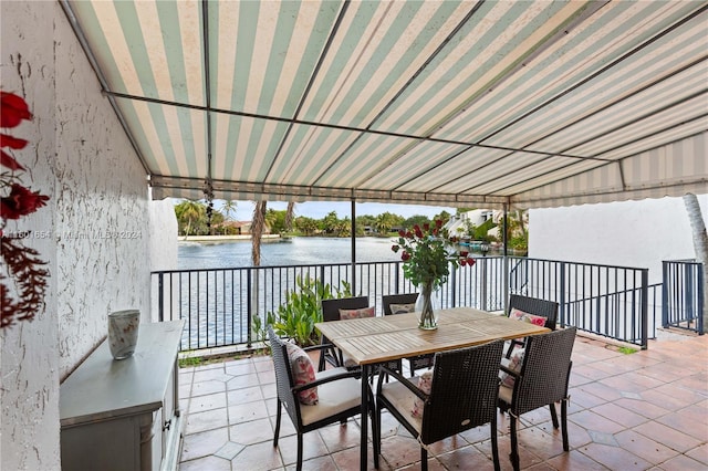 view of patio / terrace with a balcony and a water view