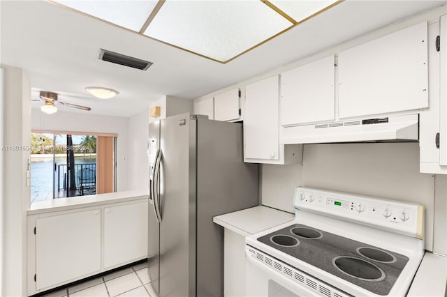 kitchen featuring stainless steel refrigerator with ice dispenser, light tile flooring, stove, ceiling fan, and white cabinetry