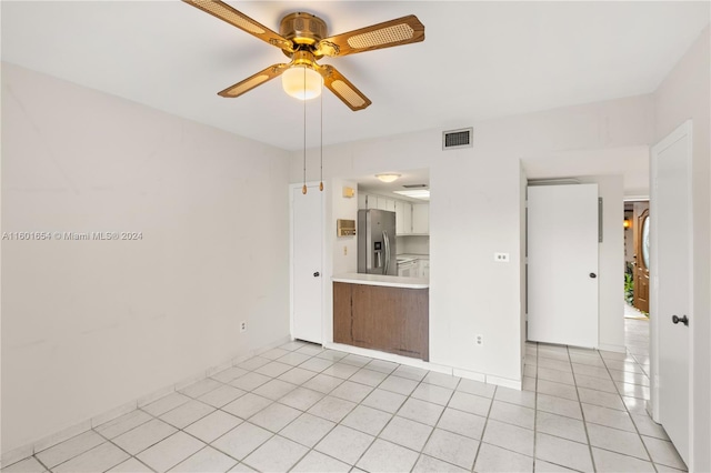 spare room featuring ceiling fan and light tile floors