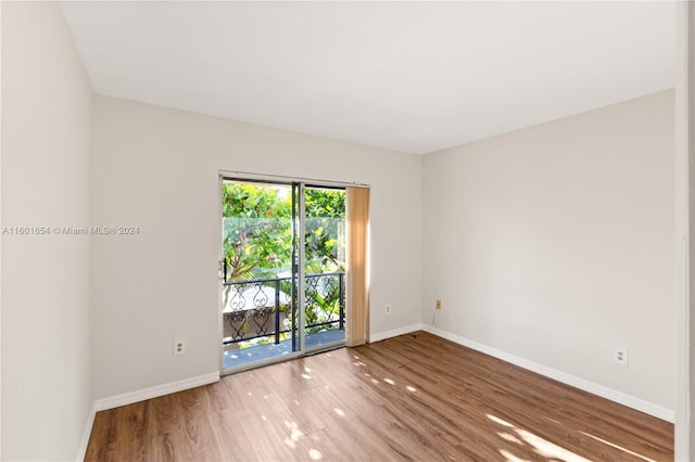 empty room featuring plenty of natural light and hardwood / wood-style floors