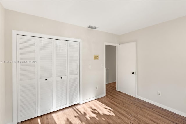 unfurnished bedroom featuring a closet and wood-type flooring