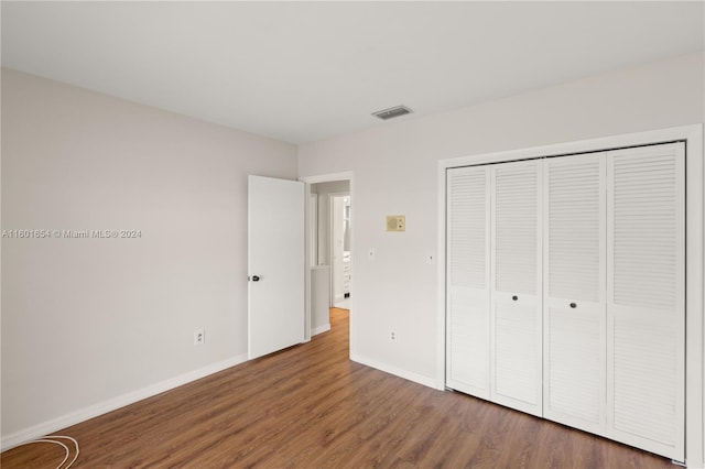 unfurnished bedroom featuring dark wood-type flooring and a closet