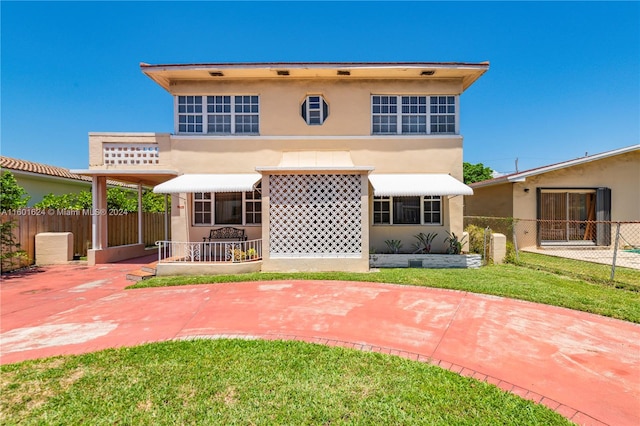 back of property featuring a patio and a yard