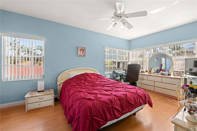 bedroom with multiple windows, ceiling fan, and light hardwood / wood-style flooring