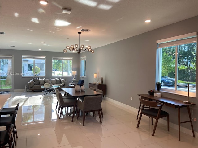 tiled dining area featuring plenty of natural light and a notable chandelier