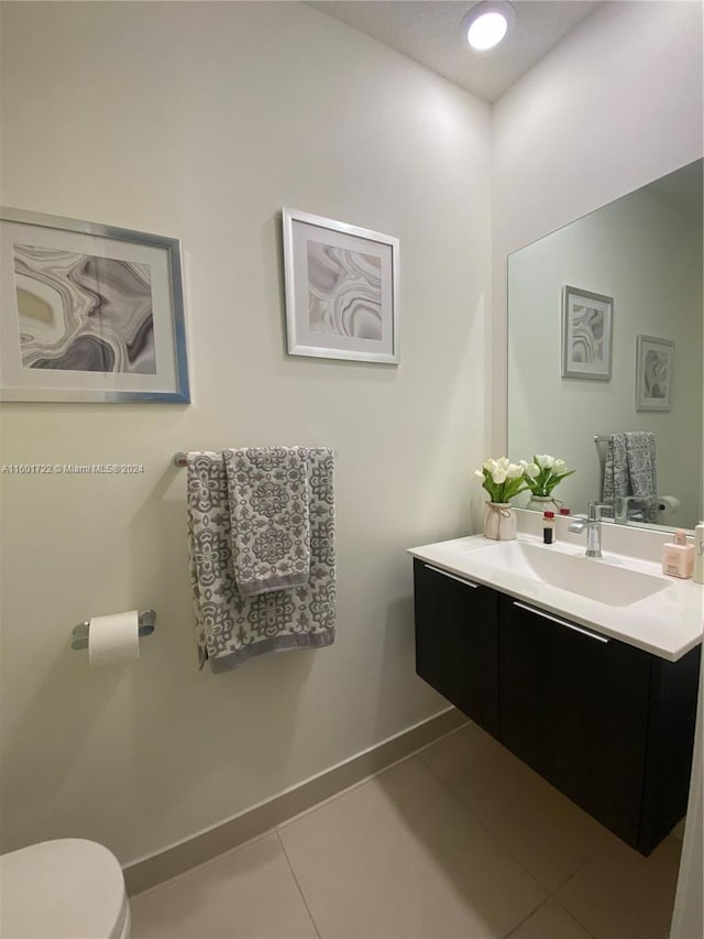 bathroom with tile patterned flooring, vanity, and toilet