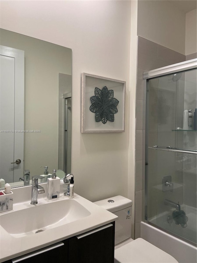 bathroom with enclosed tub / shower combo, toilet, and vanity