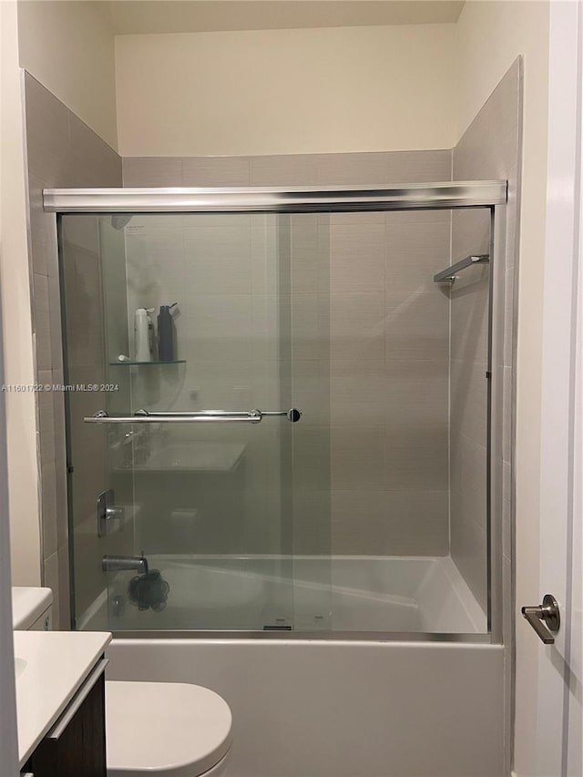 full bathroom featuring shower / bath combination with glass door, vanity, and toilet