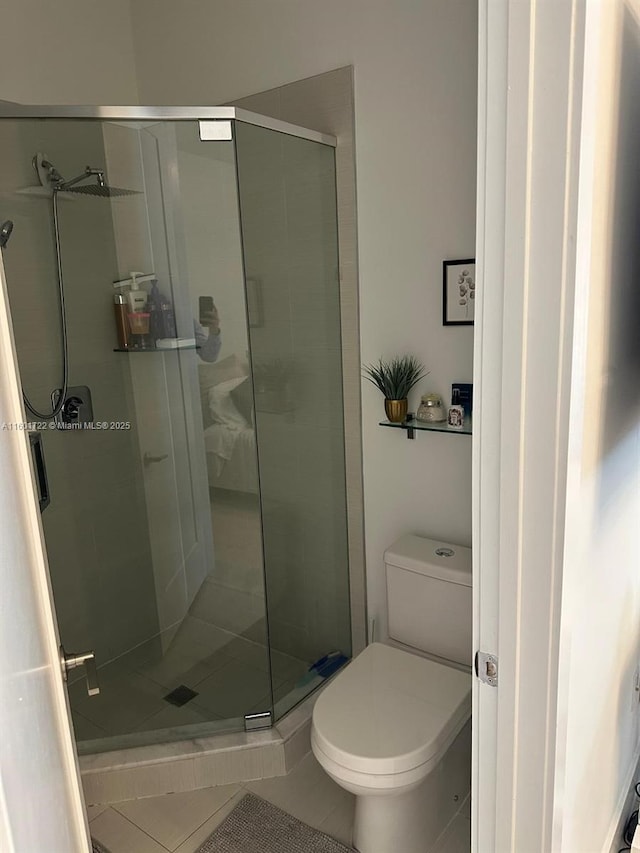full bathroom featuring a stall shower, tile patterned floors, and toilet