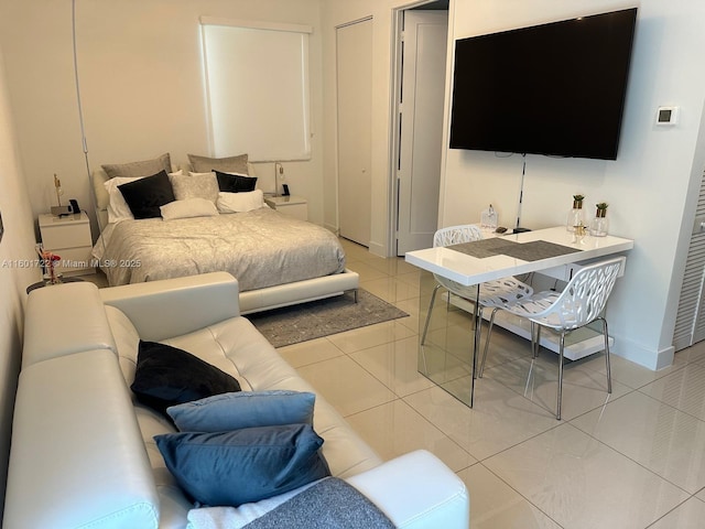 bedroom featuring light tile patterned flooring and baseboards