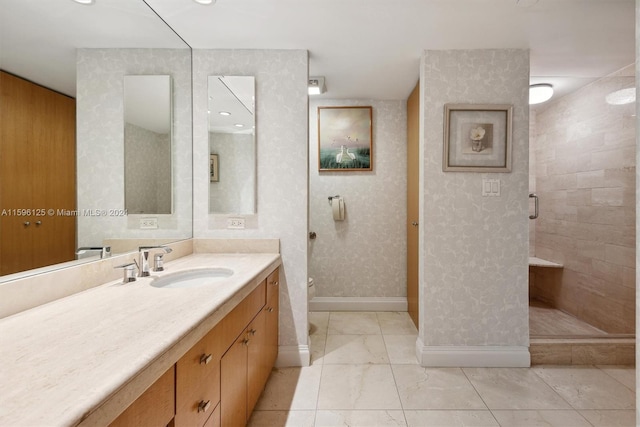 bathroom featuring tiled shower, vanity, and toilet