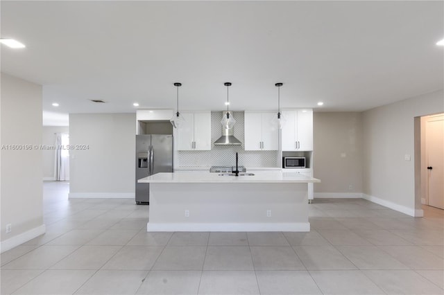 kitchen with tasteful backsplash, a kitchen island with sink, stainless steel appliances, wall chimney range hood, and white cabinets